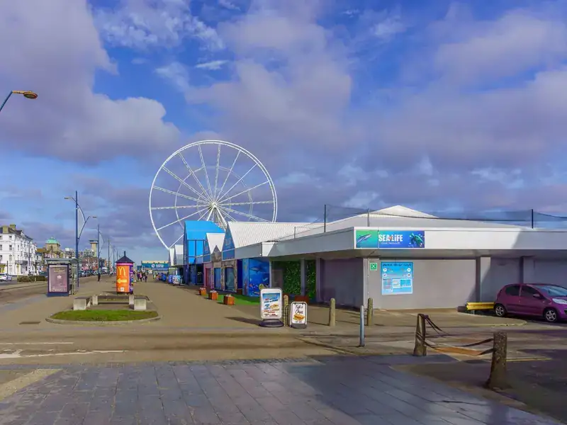 The promenade on Great Yarmouth seafront on a sunny day, with the big wheel beyond