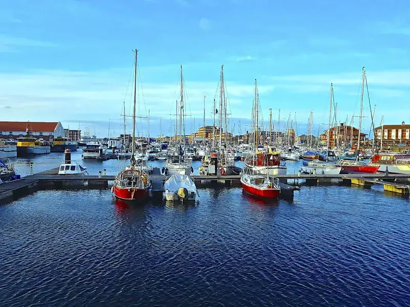 Sailing boats and fishing boats moored in Hartlepool marina on a bright day
