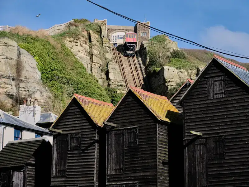 The East Hill Cliff Railway above the tall black net shops in Hastings Old Town
