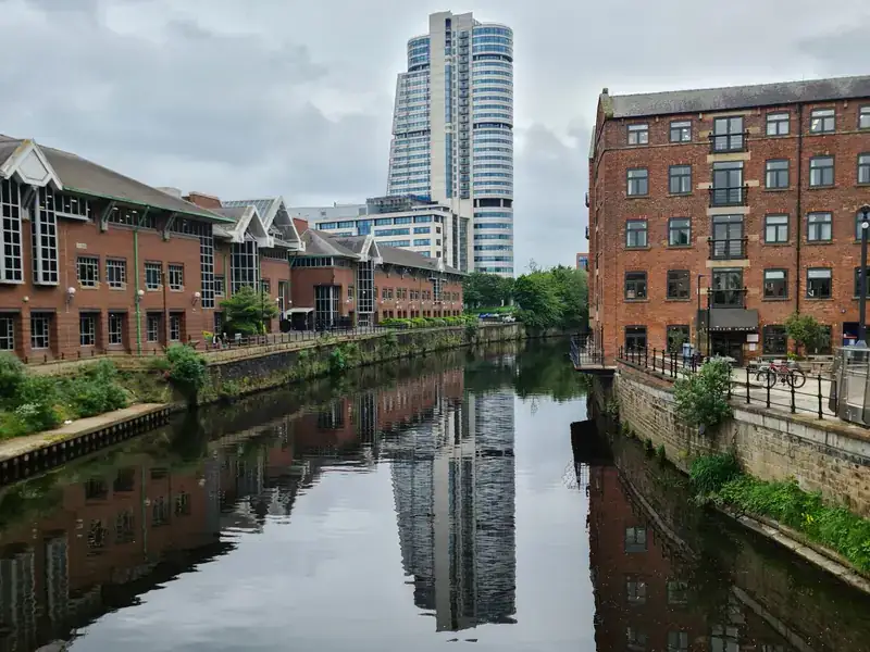 Converted warehouses and Bridgewater Place reflected in the River Aire in Leeds