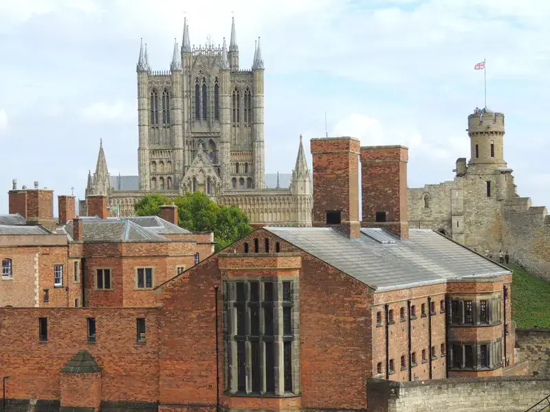 Lincoln Cathedral's towers rising above red-brick buildings and the walls of Lincoln Castle