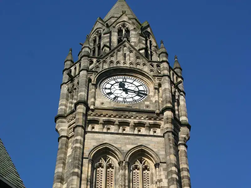 The Gothic clock tower of Rochdale Town Hall against a clear blue sky