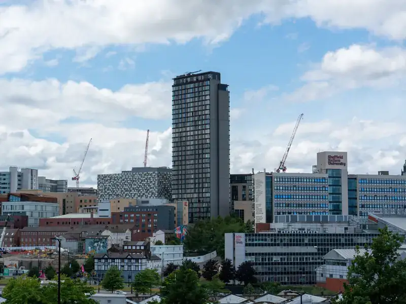 The Sheffield city centre skyline under a summer sky, with St Paul's Tower rising above Sheffield Hallam University