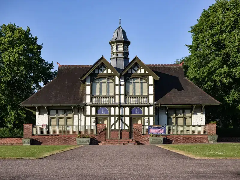 The black-and-white timbered pavilion in Burslem Park, Stoke-on-Trent, under a blue sky