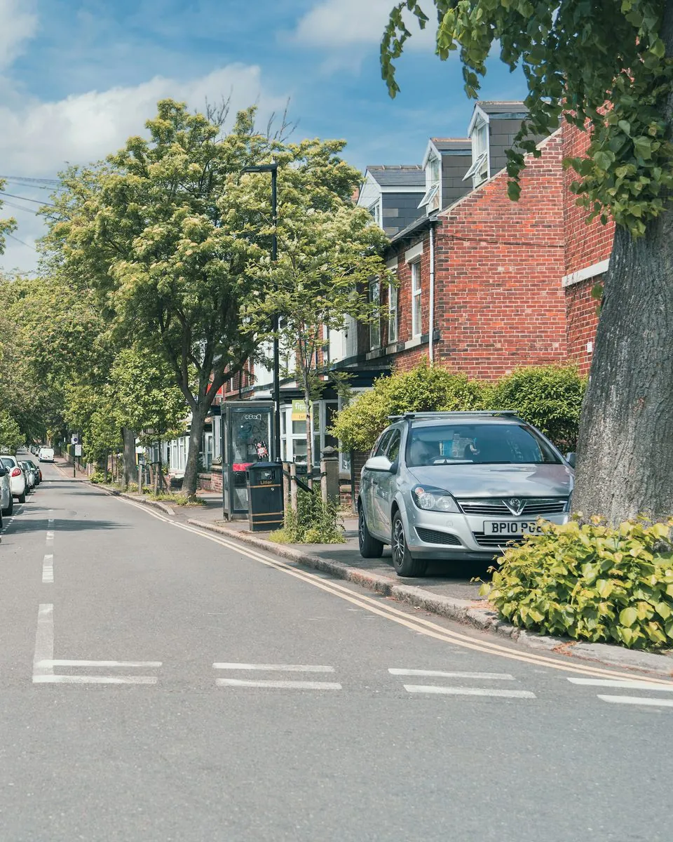 A silver Vauxhall Astra parked on a tree-lined terraced street in Sheffield